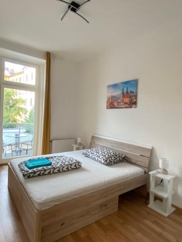 una camera con un letto e una grande finestra di Designed apartment next to Vaclav square with terrace and private garage a Praga