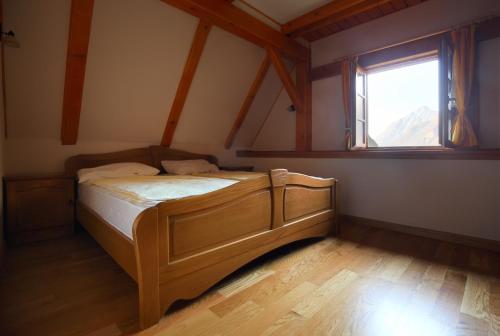 a bedroom with a bed in a room with a window at Zadnjica Holiday House in Soča