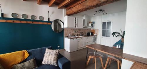 un salon avec un canapé bleu et une cuisine dans l'établissement La maison du grand clar arles, à Arles