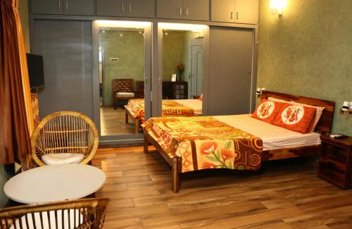 ポンディシェリにあるPenthouse 2BHK with Bathtub and Terraceのベッド2台とテーブルが備わるホテルルームです。