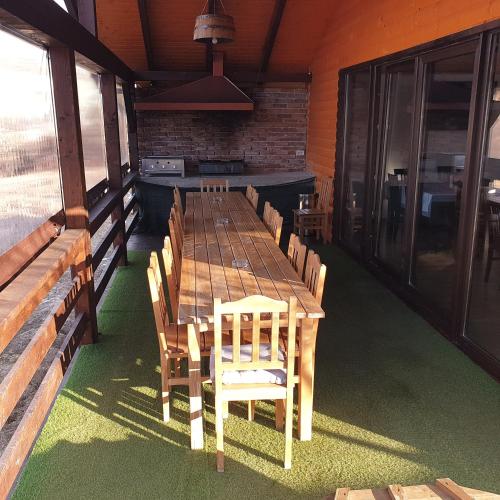 a long wooden table and chairs in a room at Popas 8 Odăi in Poiana Aiudului