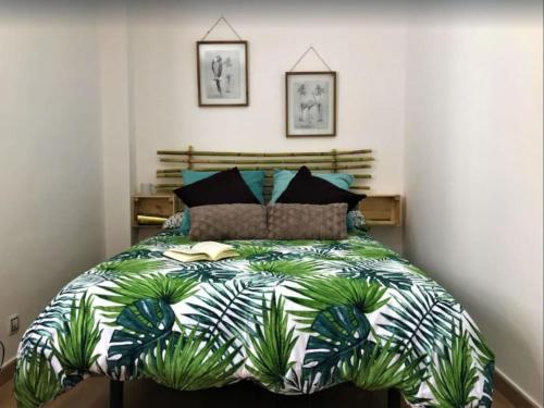 ein Schlafzimmer mit einem großen Bett mit einer grünen Bettdecke in der Unterkunft Nature Vista Agaete & Parking in Agaete