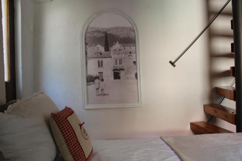 a picture of a house on the wall next to a bed at Stone house Castellum in Kaštela