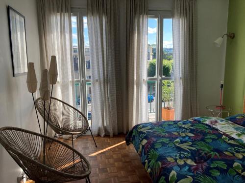 um quarto com 2 cadeiras, uma cama e uma janela em Au fil de la Seine em Vernon