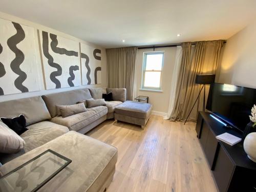 a living room with a couch and a table at Luxurious Beach House Chesil Beach. Sleeps 6 in Castletown