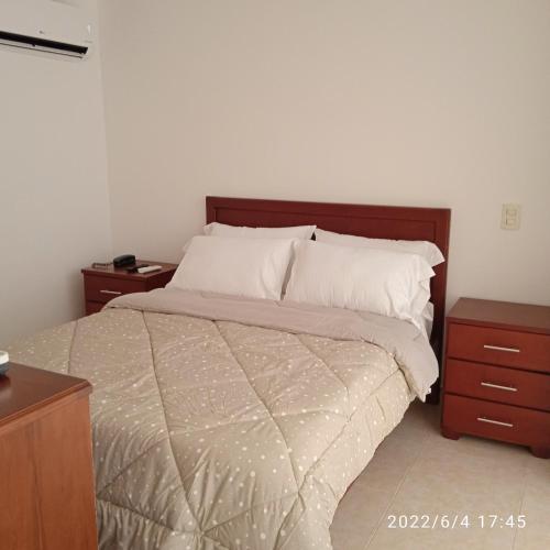 a bedroom with a bed and two night stands at Apartaestudio atractivo, confortable, muy completo, familiar in Bucaramanga