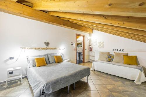 a bedroom with two beds and wooden ceilings at Le Quattro Stelle Villa in Cardano al Campo