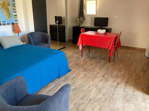 une pièce avec une table et des chaises rouges et une télévision dans l'établissement A Stalla, à Piana