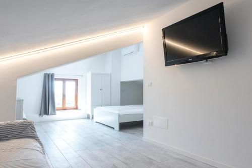 um quarto com uma cama e uma televisão de ecrã plano na parede em S271 - Sirolo, deliziosa mansarda condizionata arredata con gusto em Sirolo