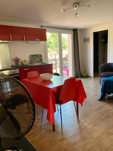 a kitchen with a red table and chairs in a room at A Stalla in Piana