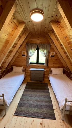a bedroom in a log cabin with two beds at Family House Aurora Žabljak in Žabljak