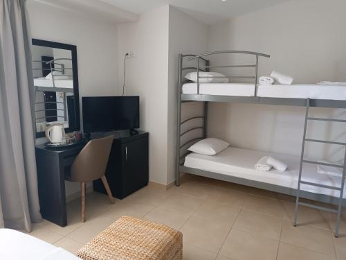 Habitación con 2 literas y escritorio con ordenador. en Hotel MINOS en Preveza