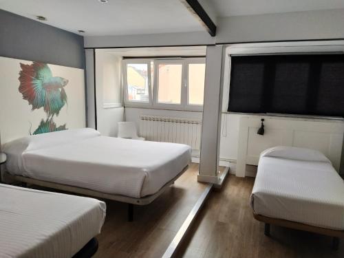 - une chambre avec 2 lits et une fenêtre dans l'établissement Hostal Mara, à La Corogne