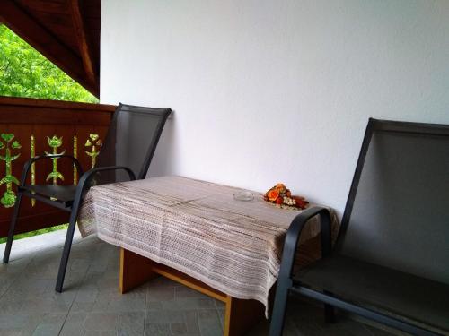 a table and two chairs on a porch at Casa Lacul Mierlei in Sovata
