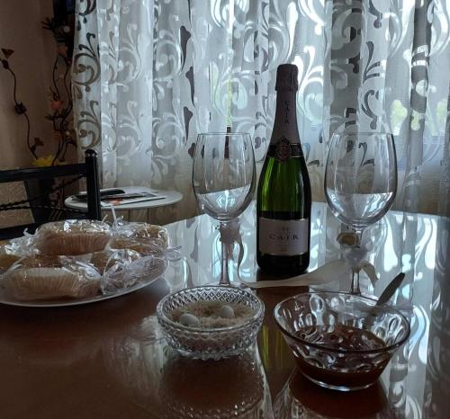 butelka wina na stole z dwoma kieliszkami wina w obiekcie Glyfada Villas III w mieście Paralio Astros