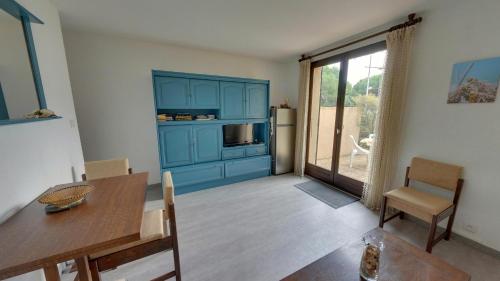 un salon avec une table et un meuble bleu dans l'établissement Gruissan: Maisonnette T2 avec jardin, à Gruissan