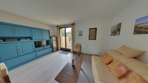 un salon avec un canapé et une table dans l'établissement Gruissan: Maisonnette T2 avec jardin, à Gruissan