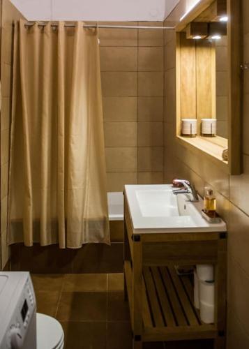 a bathroom with a sink and a shower curtain at Alfa house w/ view & barbeque in Pythagorion in Pythagoreio
