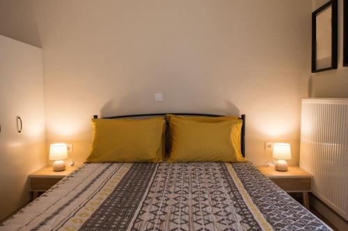 a bedroom with a bed with yellow pillows and two lamps at Alfa house w/ view & barbeque in Pythagorion in Pythagoreio