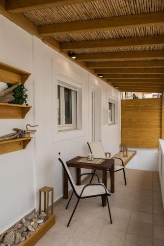 a patio with a table and chairs and a window at Alfa house w/ view & barbeque in Pythagorion in Pythagoreio