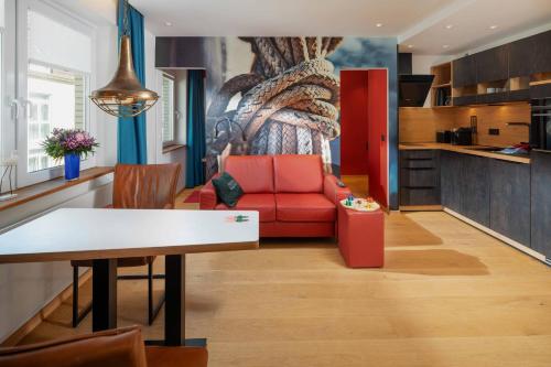 a living room with a red couch and a table at neyland apartments Norderney in Norderney
