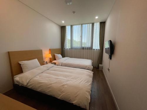 ein Hotelzimmer mit 2 Betten und einem TV in der Unterkunft Hotel Icc in Daejeon