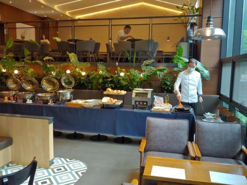 a man standing at a counter in a restaurant at Hotel Icc in Daejeon