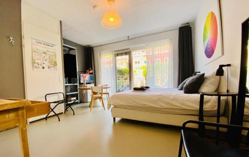 Private Studio with free car parking في أمستردام: غرفة نوم بسرير وطاولة وكراسي