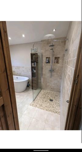 a bathroom with a tub and a shower and a bath tub at Sunset cottage in Burry Port