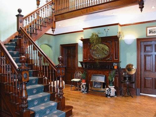 a living room with a staircase and a clock at The Grange Hotel in Kings Lynn