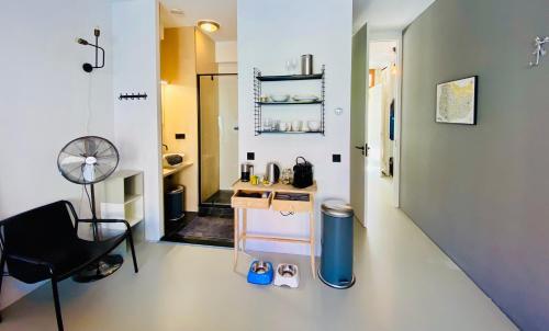 Private Studio with free car parking في أمستردام: غرفة بها مكتب وكرسي في غرفة
