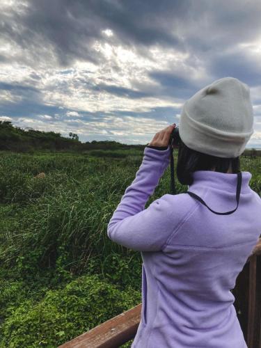 a woman taking a picture of a field of grass at Hostería Jasy in Colonia Carlos Pellegrini