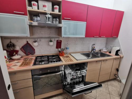 una pequeña cocina con armarios rojos y fregadero en ARCO ANTICO, en Nardò