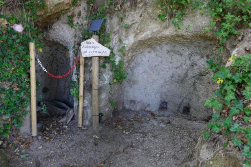 a small cave with a sign on a wall at Agriturismo le Fontane - Lago di Bolsena in Grotte di Castro