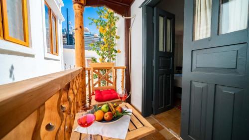 a bowl of fruit and a glass of wine on a balcony at Old Trading House in Kalkan