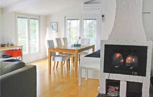 Gorgeous Home In Vikbolandet With Wifi في Arkösund: غرفة معيشة مع موقد وغرفة طعام