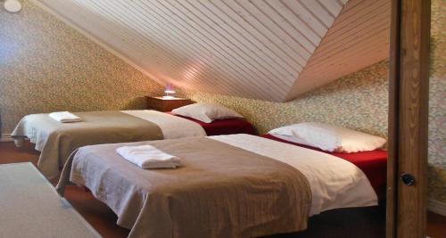 two beds in a room with a attic at Hotel & Cafe Lanterna in Nauvo