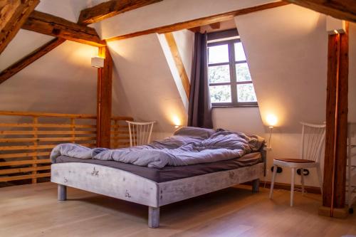 ein Schlafzimmer mit einem Bett im Dachgeschoss in der Unterkunft Schloss Mühlen in Horb am Neckar