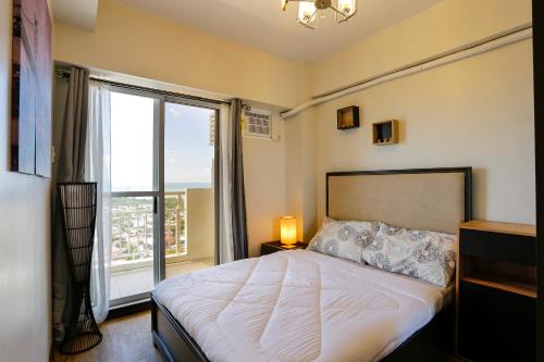 a bedroom with a bed and a large window at Verdon Parc 2 bedroom apartment Ocean View in Davao City