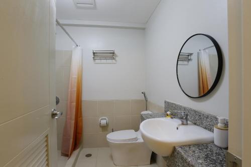 Un baño con lavabo, inodoro y espejo. en Verdon Parc 2 bedroom apartment Ocean View, en Davao City