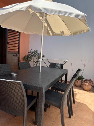 a table with an umbrella on top of it at Xenia House in Lascari