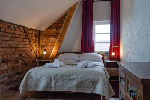 a bedroom with a bed with two towels on it at Dworek Wojanów in Wojanów