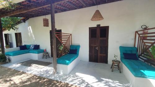 a patio with blue couches on a white wall at Pousada Maresia in Atins