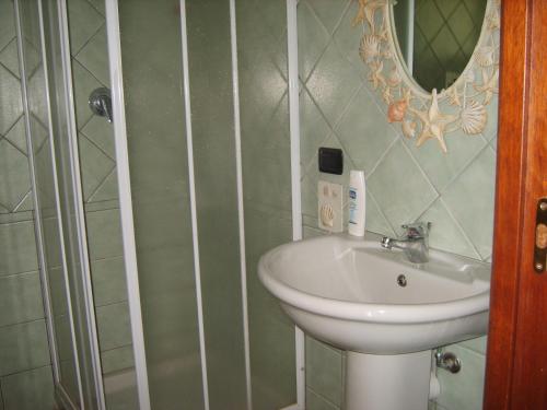 un bagno con lavandino e specchio di VISTA MARE a Budoni