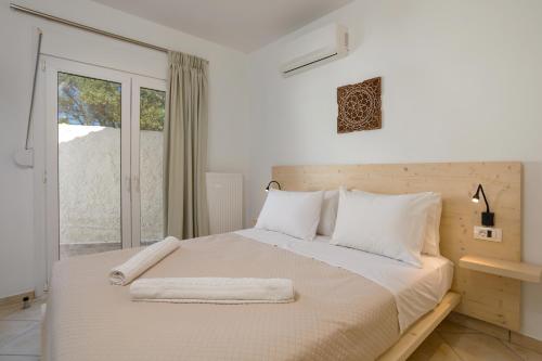 a white bedroom with a large bed with white pillows at Icabaru Zante Holiday House in Zakynthos Town