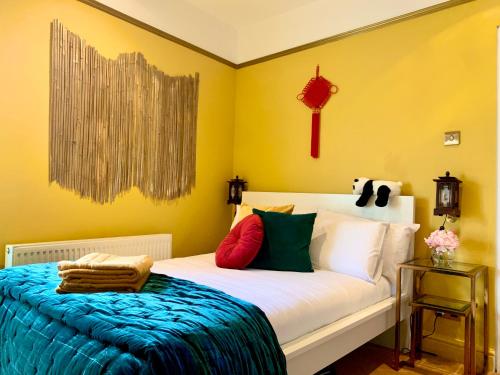 a bedroom with a white bed with colorful pillows at London Chinatown Apartments in London