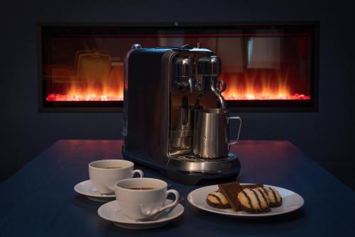 a coffee maker and two cups of coffee and cookies at Number 4 in Longford