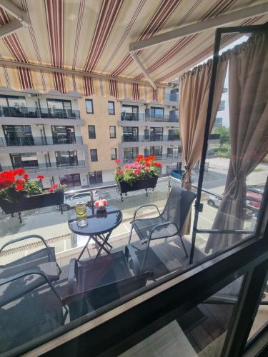 a balcony with a table and chairs and a building at Apartament Alina in Saturn