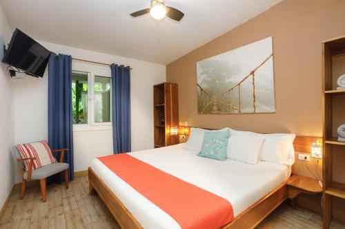 a hotel room with a bed and a tv at Kalawala in Puerto Viejo
