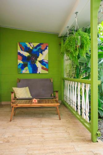 a green room with a bench and a painting at Kalawala in Puerto Viejo